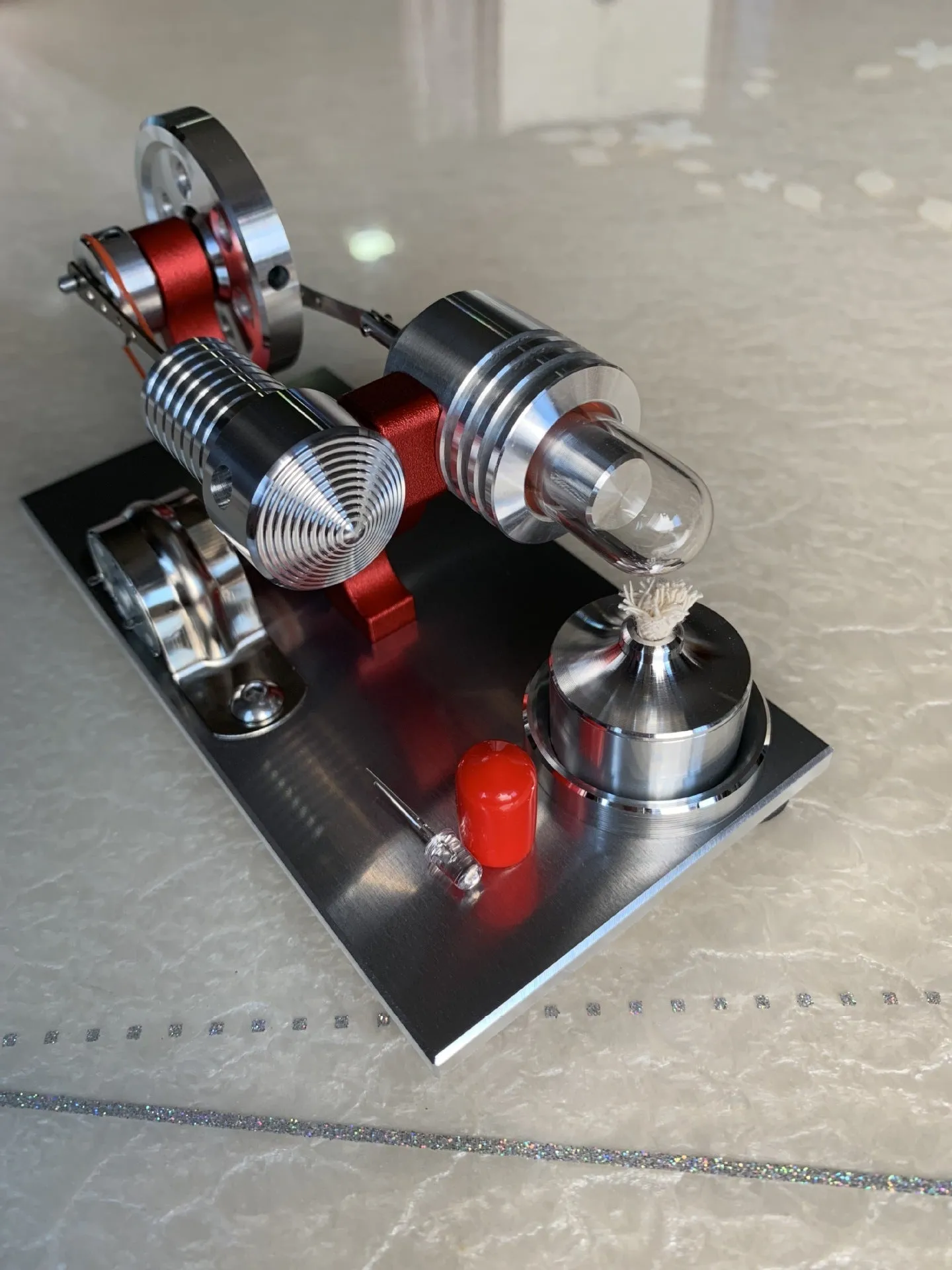 2019 Red upgrade miniature Stirling engine toy on a desk, 155x80x85mm, showing flywheel and cylinder