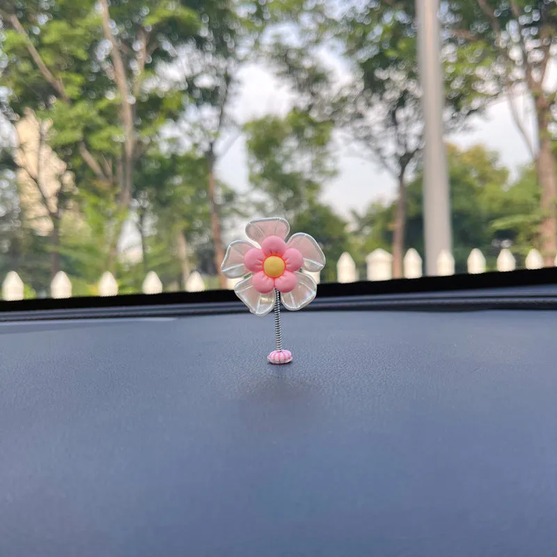 Small colourful plastic car decoration shaped like a swing, shown in multiple colour options.