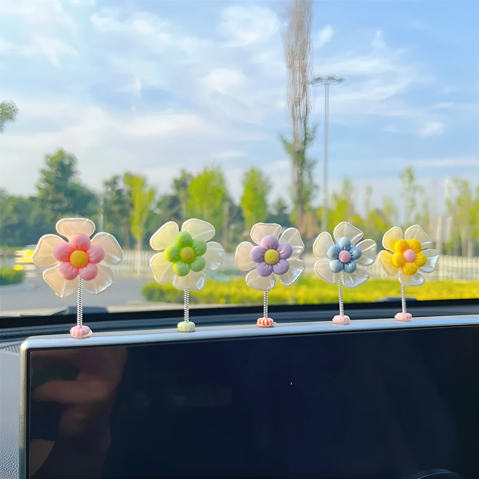 Small colourful plastic car decoration shaped like a swing, shown in multiple colour options.
