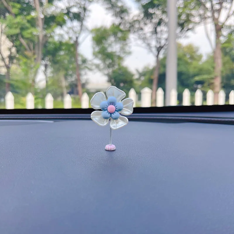 Small colourful plastic car decoration shaped like a swing, shown in multiple colour options.