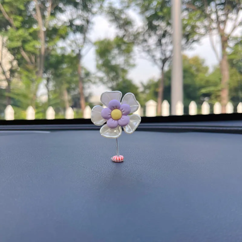 Small colourful plastic car decoration shaped like a swing, shown in multiple colour options.