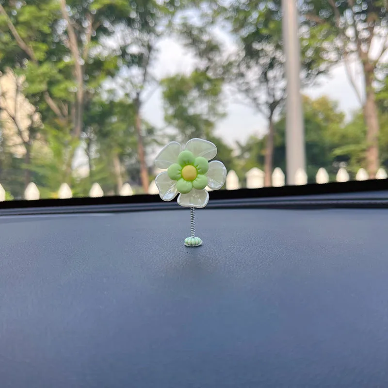 Small colourful plastic car decoration shaped like a swing, shown in multiple colour options.