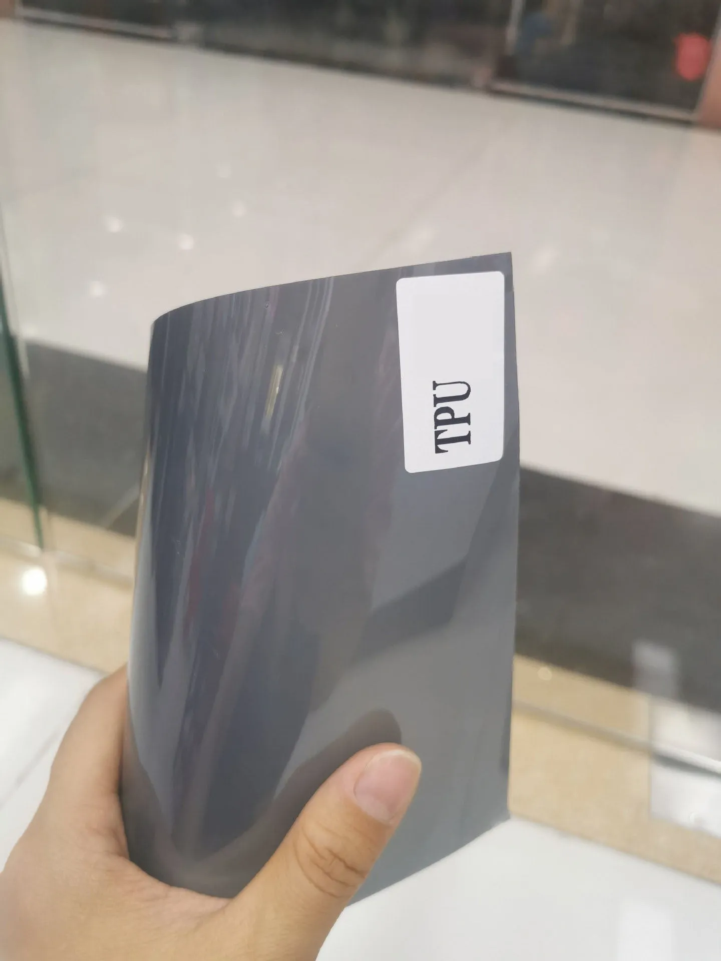 Roll of 30cm wide dark grey TPU protective film for car LED lamp protection.