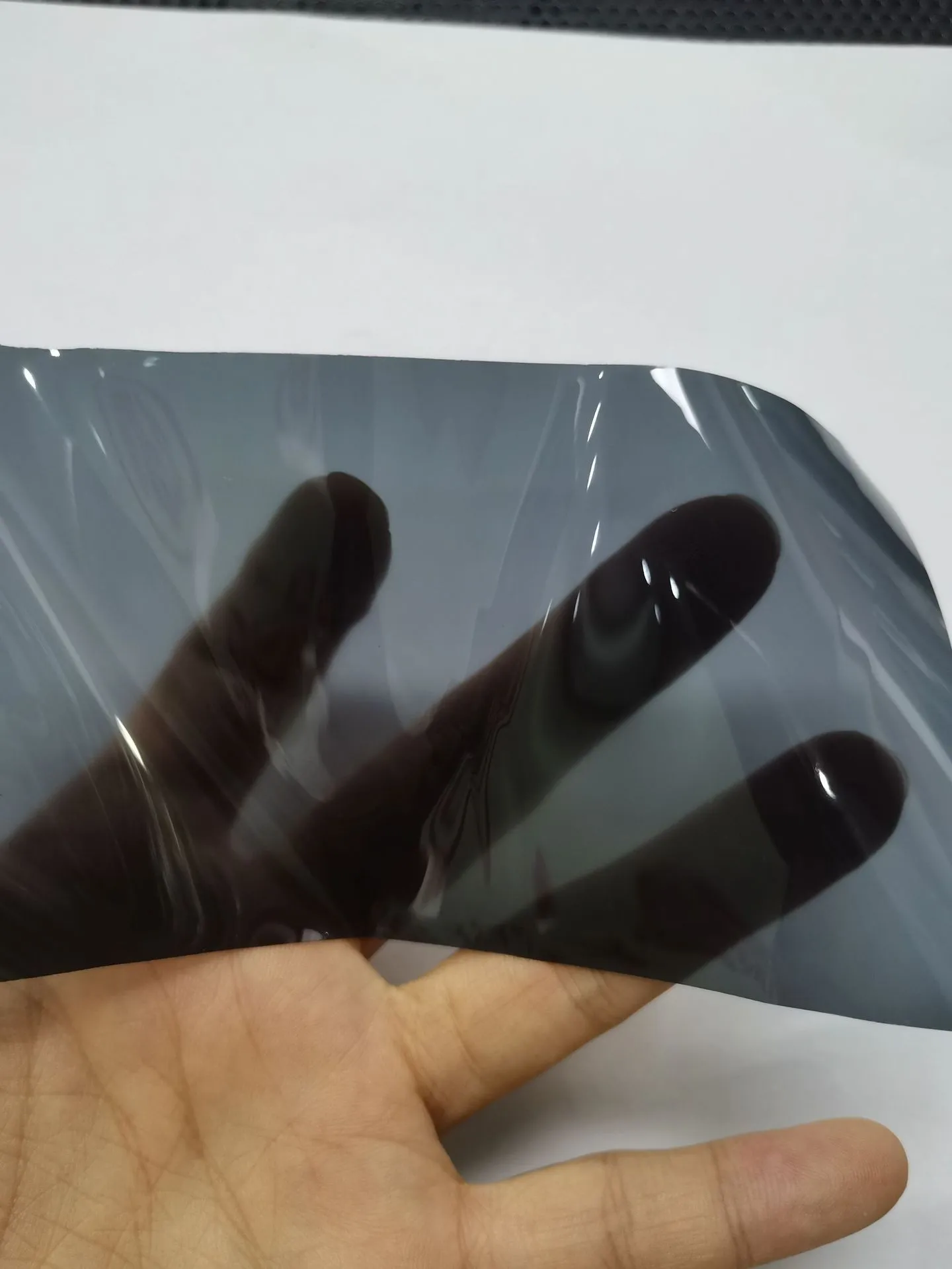 Roll of 30cm wide dark grey TPU protective film for car LED lamp protection.