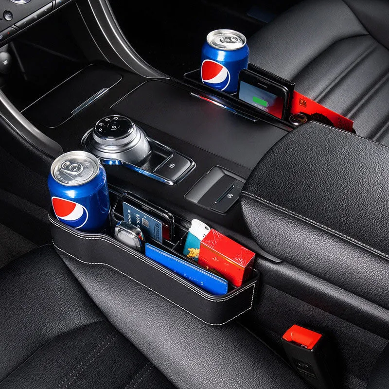 Black leather-style car seat gap storage box with cup holder and USB cable inserted between driver seat and centre console