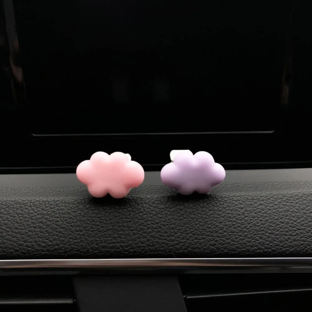 Resin cartoon car fragrance clip in pastel colours on a car air vent.