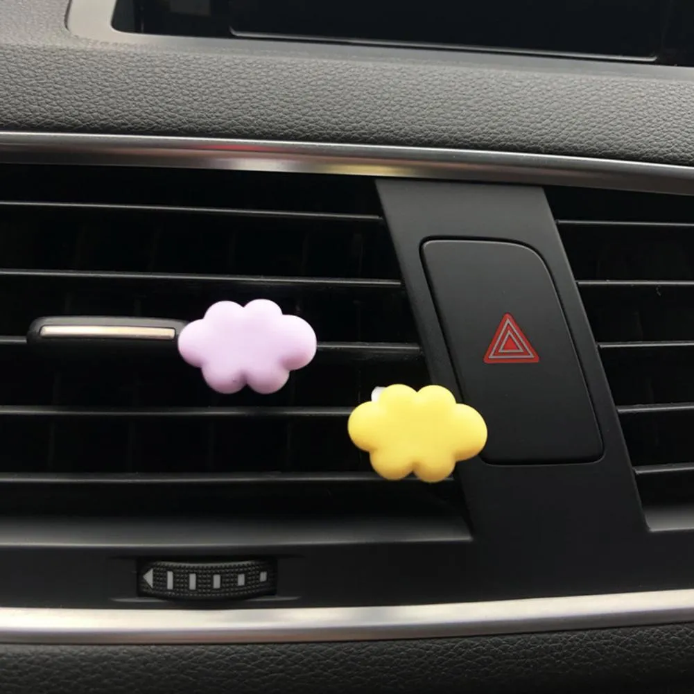 Resin cartoon car fragrance clip in pastel colours on a car air vent.