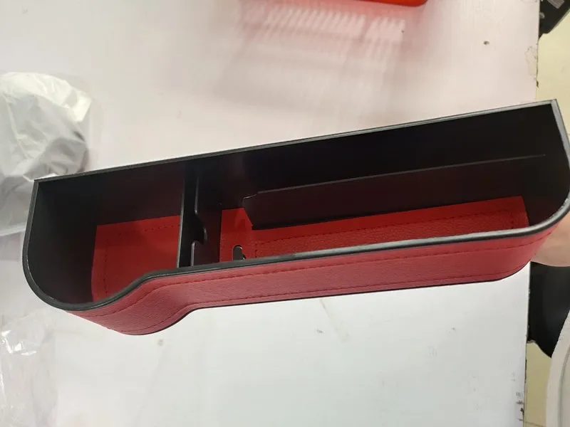 PU leather car seat gap storage box in black, showing phone and cup storage between seat and console