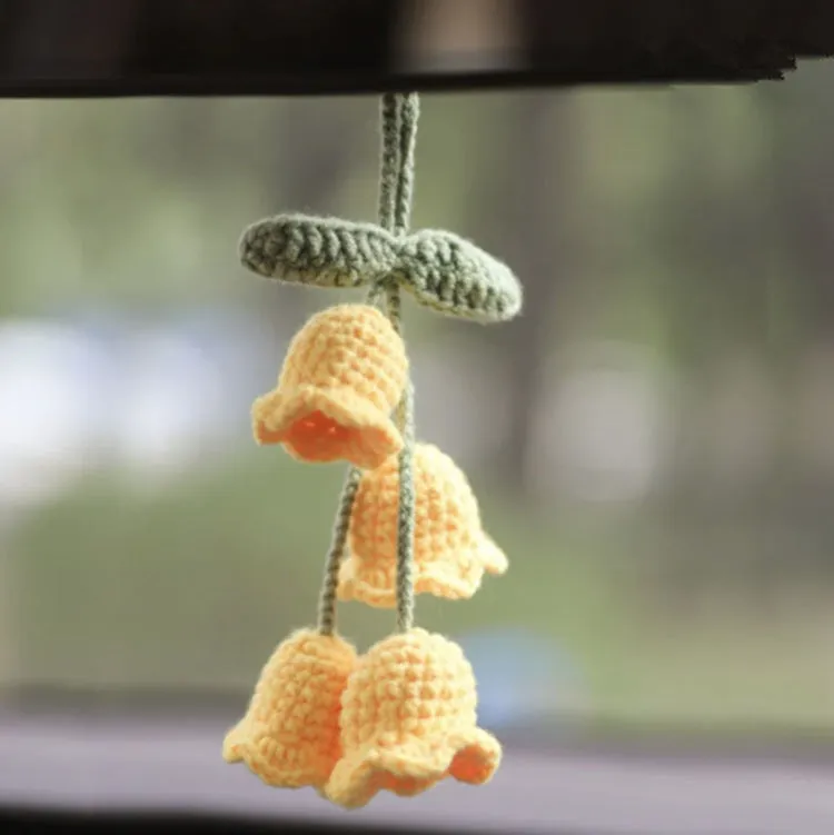 Green and white knitted wool car plant ornament with hanging rope.