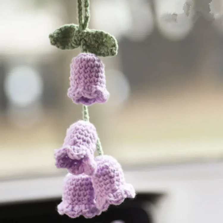 Green and white knitted wool car plant ornament with hanging rope.