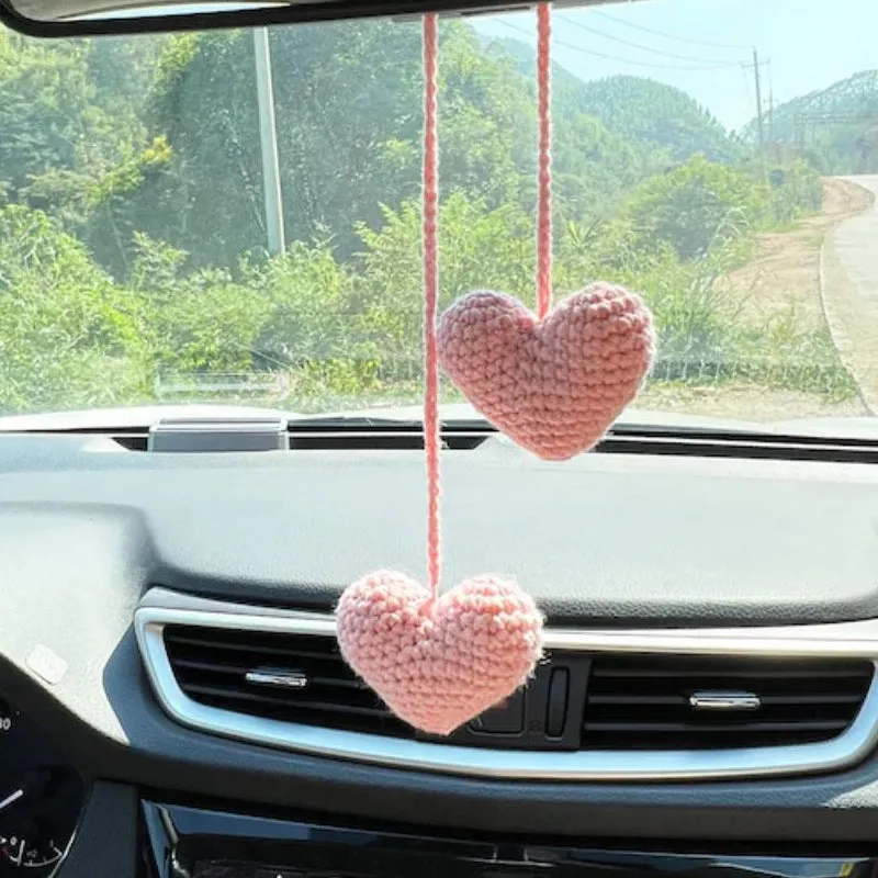 Green and white knitted wool car plant ornament with hanging rope.