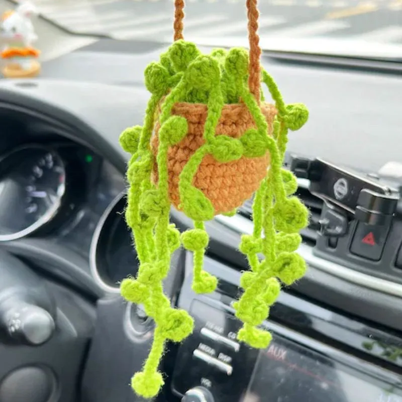 Green and white knitted wool car plant ornament with hanging rope.