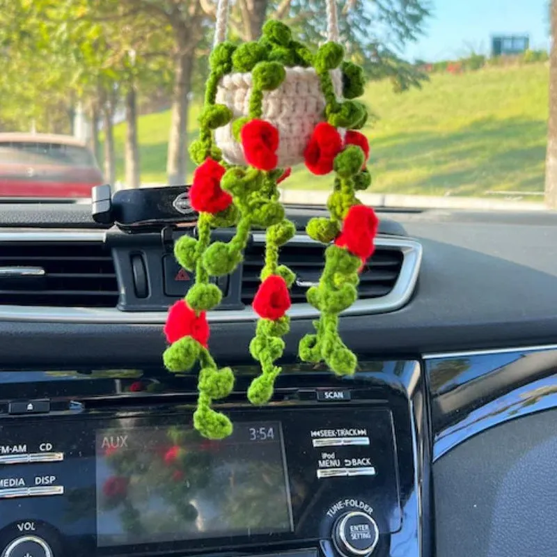 Green and white knitted wool car plant ornament with hanging rope.