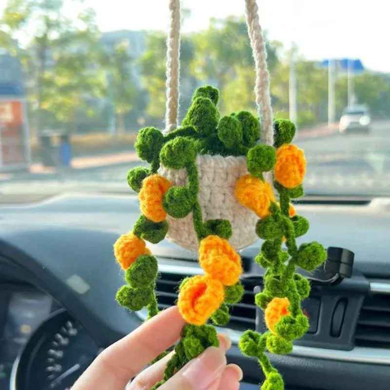 Green and white knitted wool car plant ornament with hanging rope.