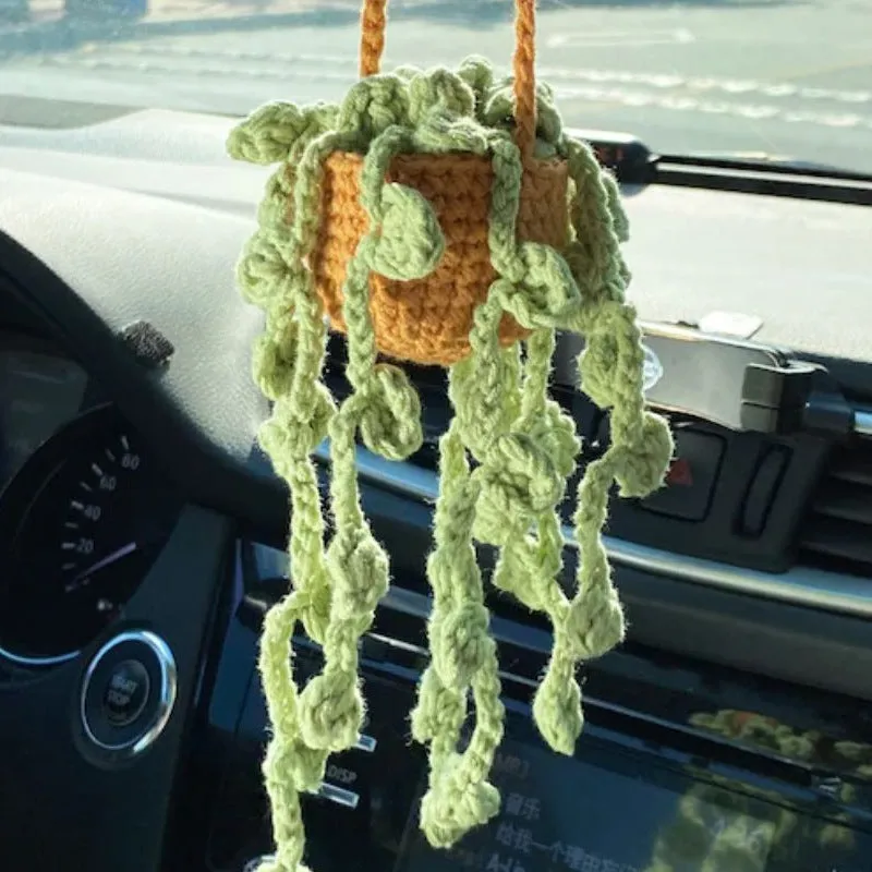 Green and white knitted wool car plant ornament with hanging rope.