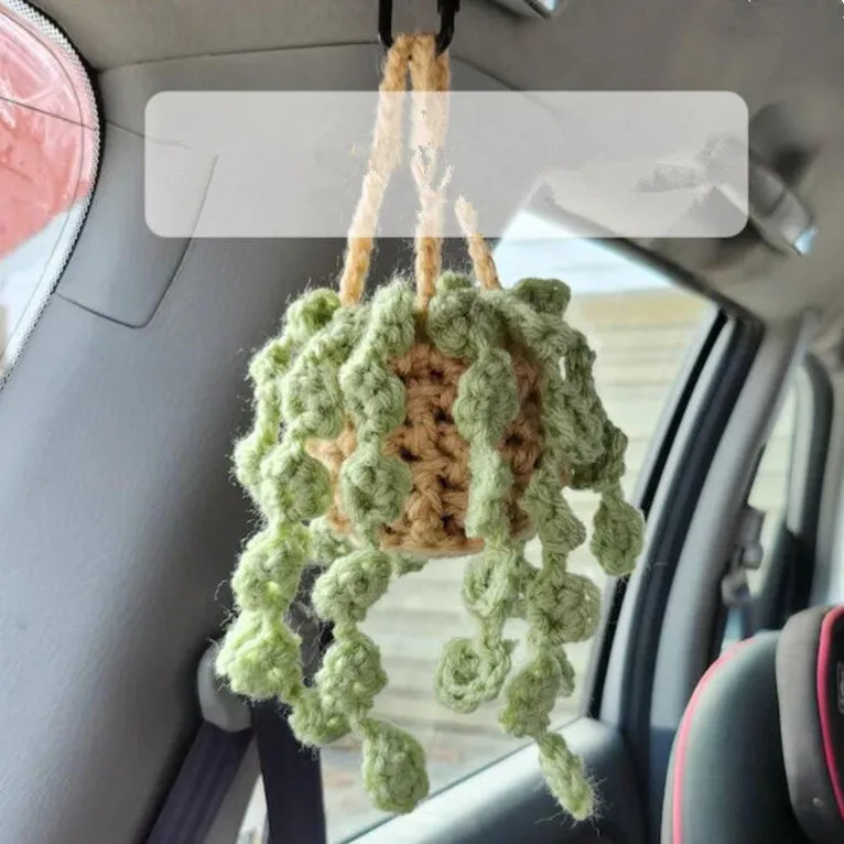 Green and white knitted wool car plant ornament with hanging rope.