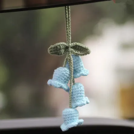 Green and white knitted wool car plant ornament with hanging rope.