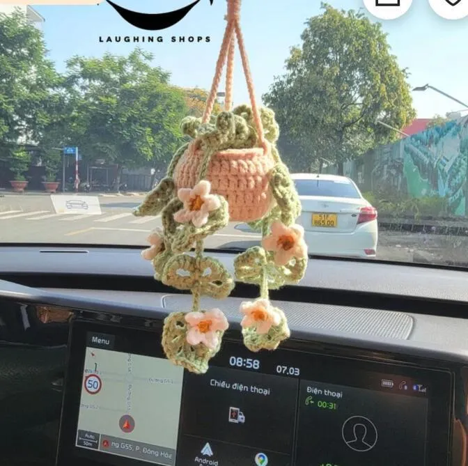 Green and white knitted wool car plant ornament with hanging rope.
