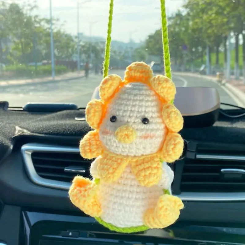 Green and white knitted wool car plant ornament with hanging rope.