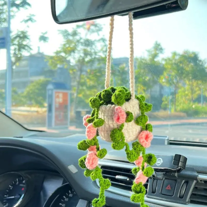 Green and white knitted wool car plant ornament with hanging rope.