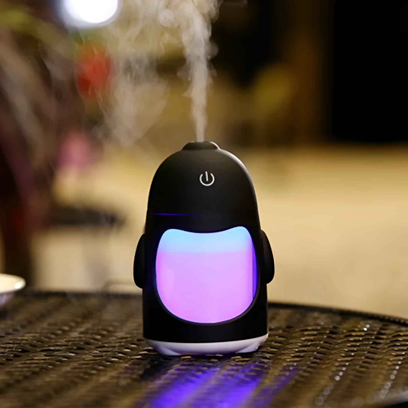 Penguin car humidifier with blue body, USB cable, and mist coming from the top