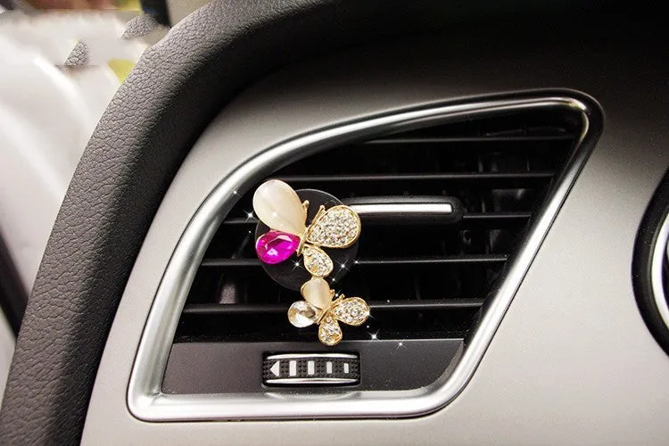 Alloy car fragrance clip with decorative charm attached to car air vent