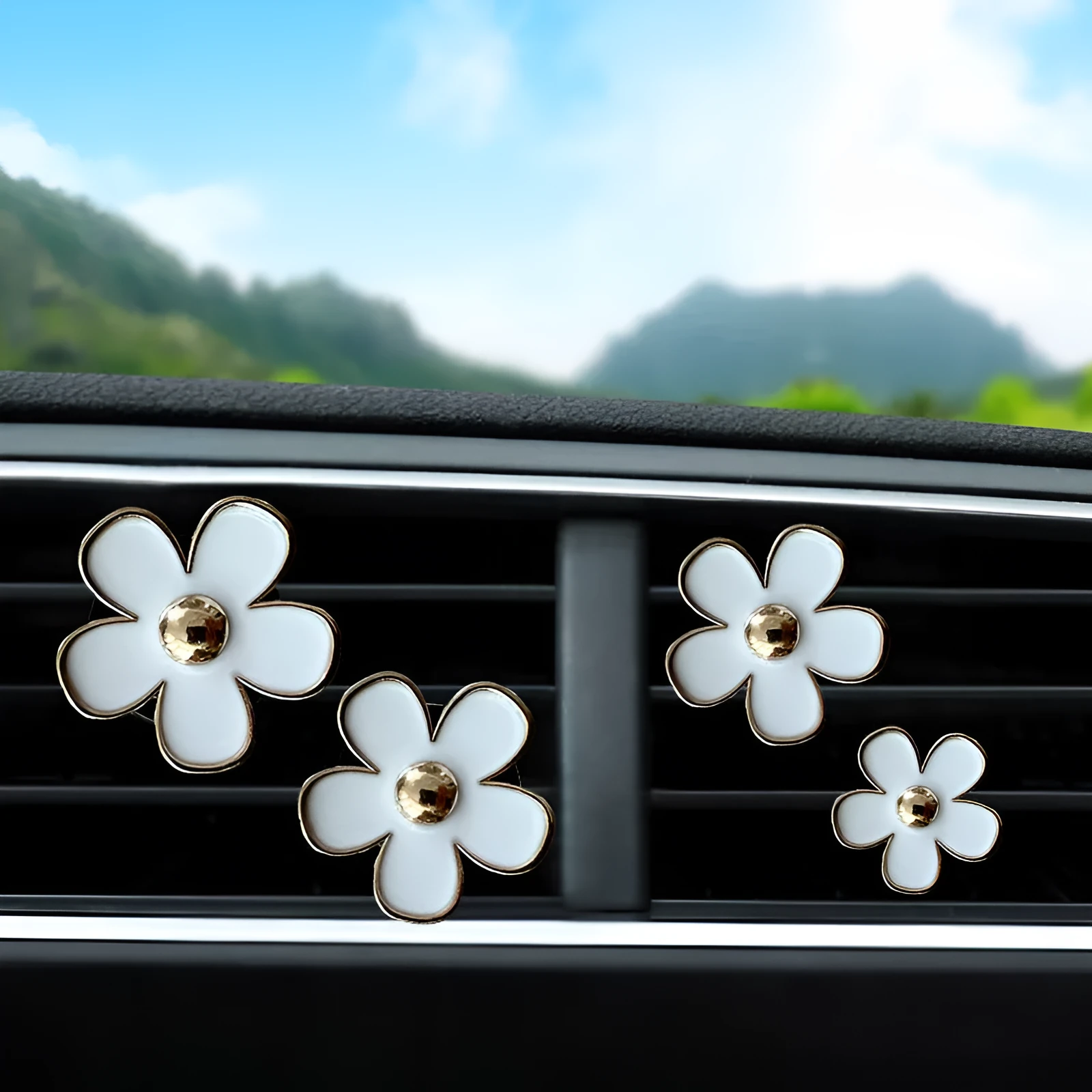 Set of four metal car air conditioning flower aromatherapy clips in assorted colours on white background