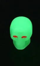 Luminous skull-shaped rubber car tyre valve cap in glow effect on a standard wheel