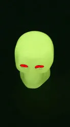 Luminous skull-shaped rubber car tyre valve cap in glow effect on a standard wheel
