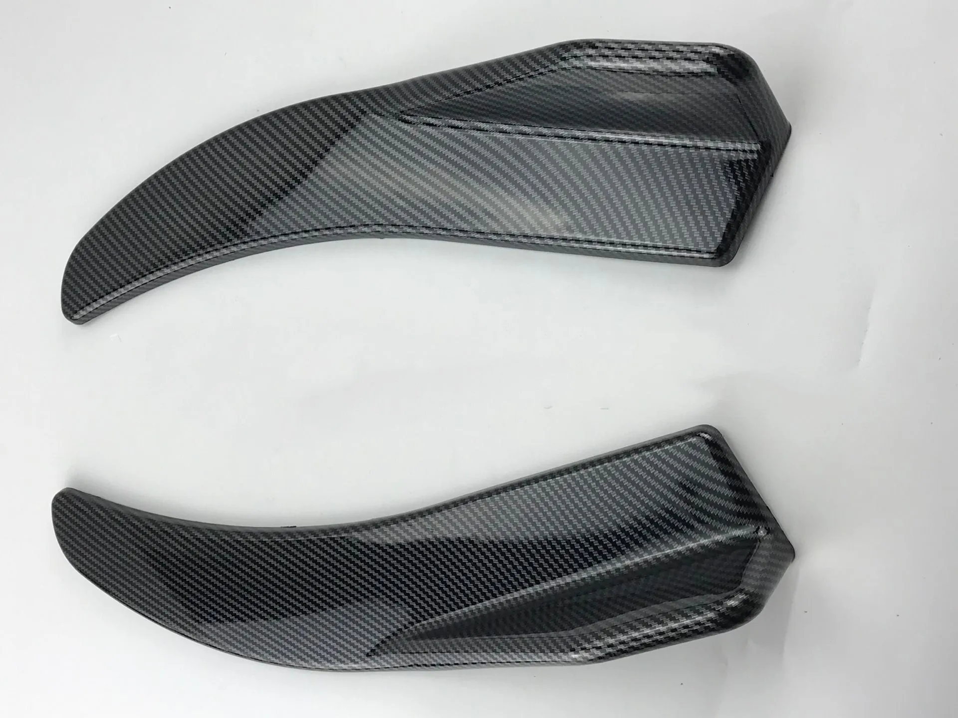 Front and rear car deflector kit for GM vehicles in black and carbon fibre finishes.