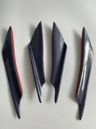 Set of four ABS plastic bumper air knife spoilers in a carbon fibre finish for car modification.