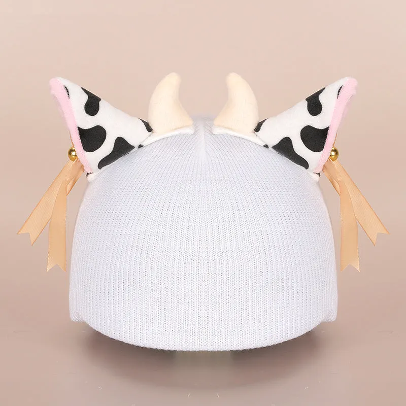 A soft plush cartoon character cover placed over a ski helmet on a snowy background.