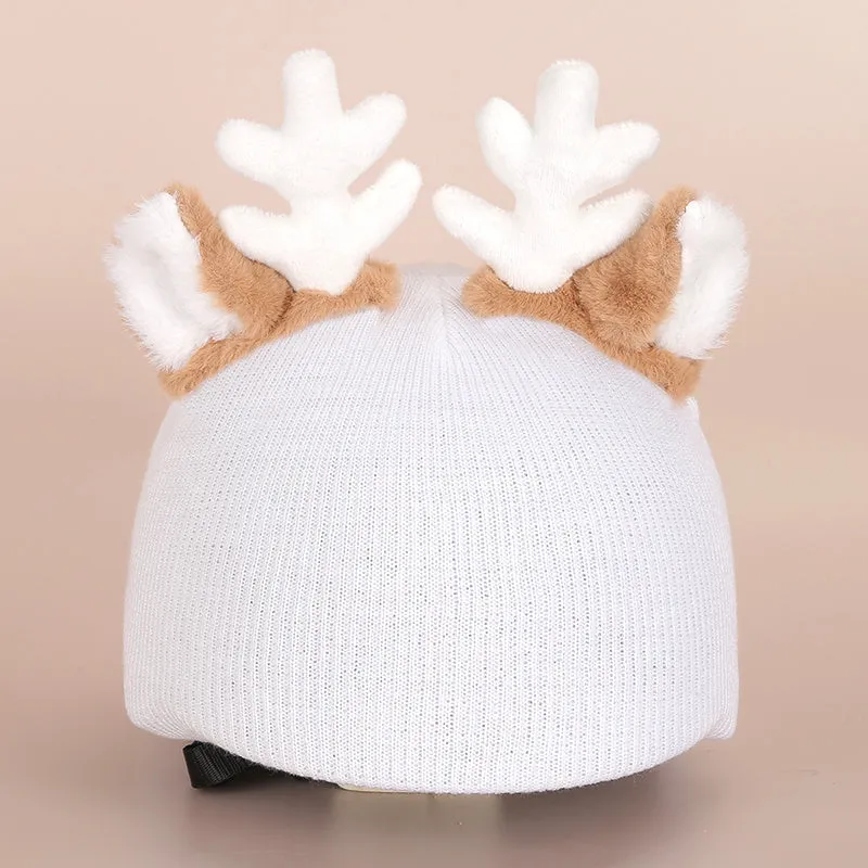 A soft plush cartoon character cover placed over a ski helmet on a snowy background.