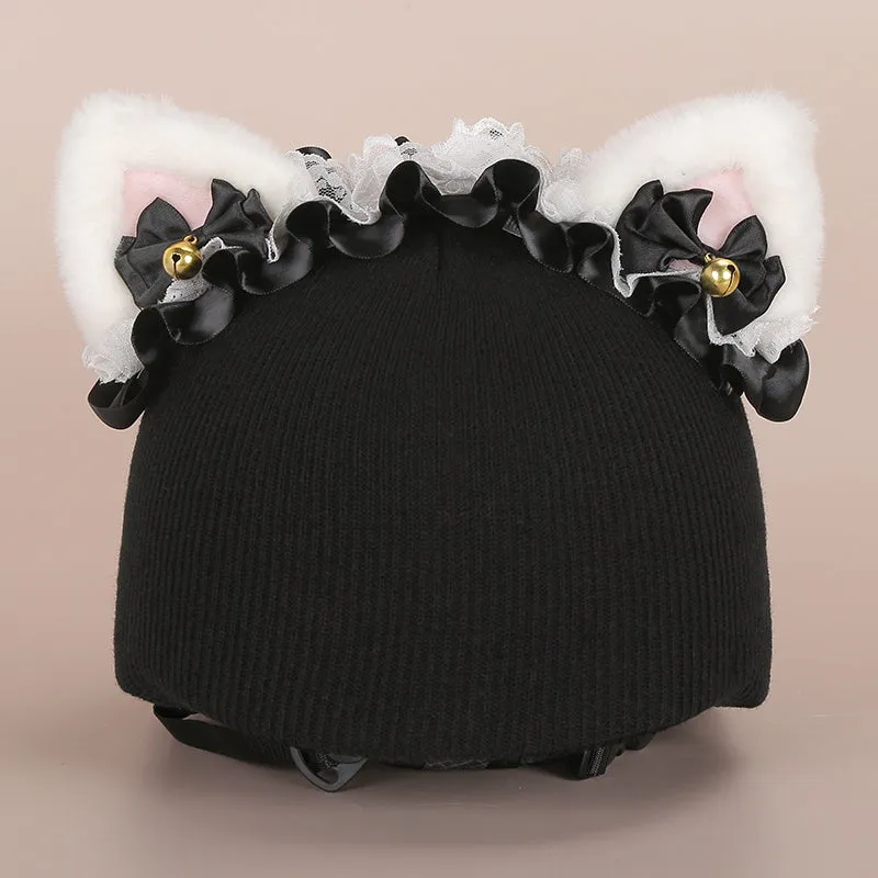 A soft plush cartoon character cover placed over a ski helmet on a snowy background.
