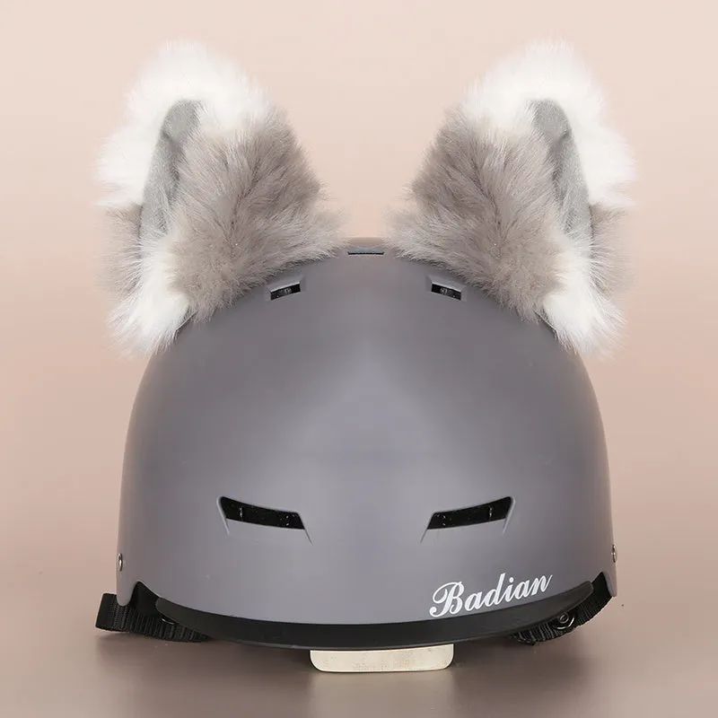 A soft plush cartoon character cover placed over a ski helmet on a snowy background.