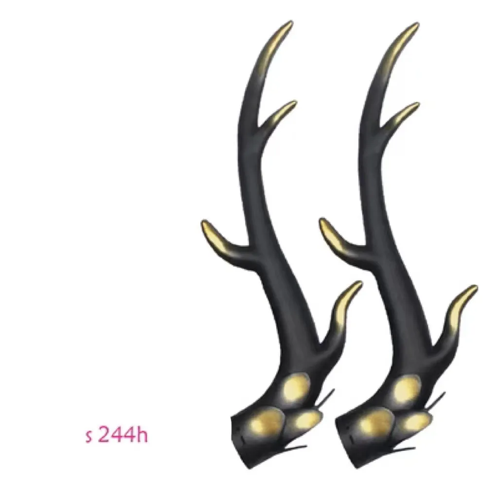 Pair of black resin dragon horn decorations next to a motorcycle helmet, showing scale and detailed texture.