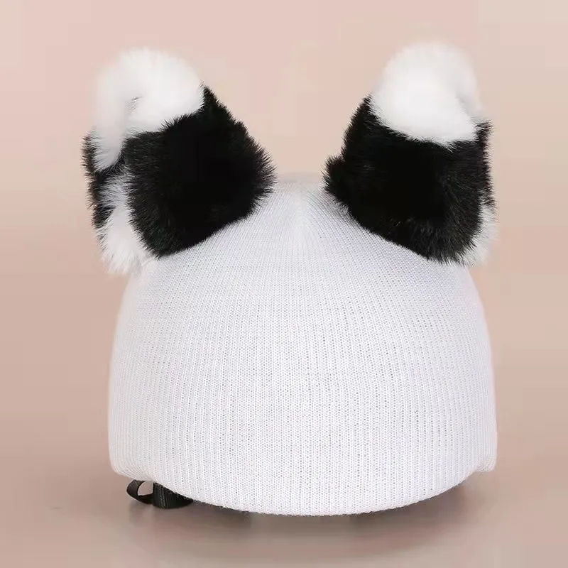 A plush fabric helmet cover with cartoon print and 3D ears, next to a matching beanie hat, on a neutral background.