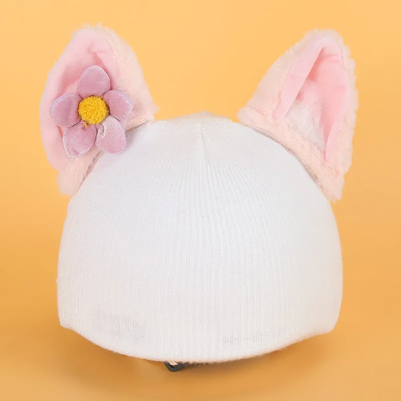 A plush fabric helmet cover with cartoon print and 3D ears, next to a matching beanie hat, on a neutral background.