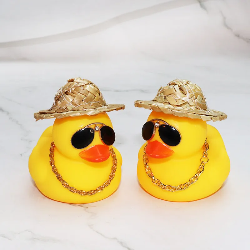 Straw hat yellow duck car ornament with adhesive gel and miniature sunglasses accessory on car dashboard