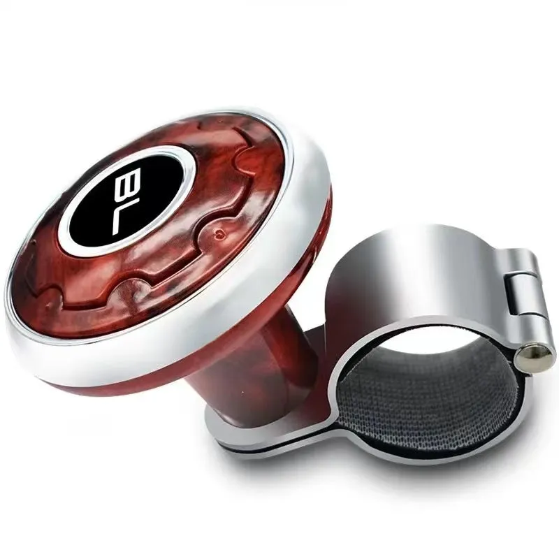Metal universal steering wheel assist ball with steel ball bearing in silver finish mounted on a car steering wheel for one-handed control