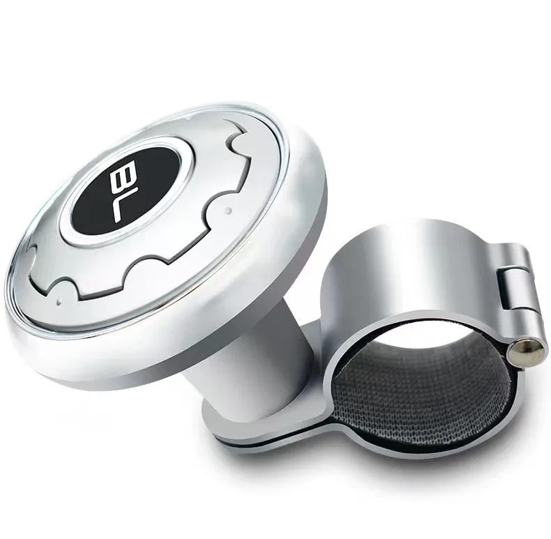 Metal universal steering wheel assist ball with steel ball bearing in silver finish mounted on a car steering wheel for one-handed control