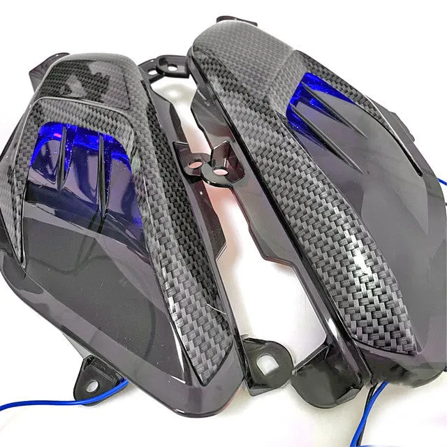 Pair of YAMAHA NMAX LED side lamps with carbon fibre trim, showing blue and red light options.