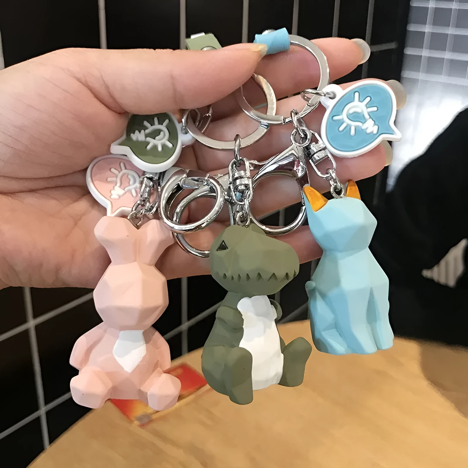 Acrylic geometric animal keychain in dinosaur style with colour buckle detail on a key ring