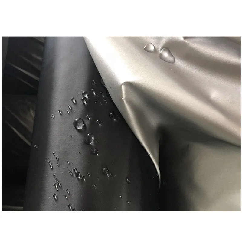 Silver-coated black taffeta universal car cover fitted over a sedan in outdoor parking
