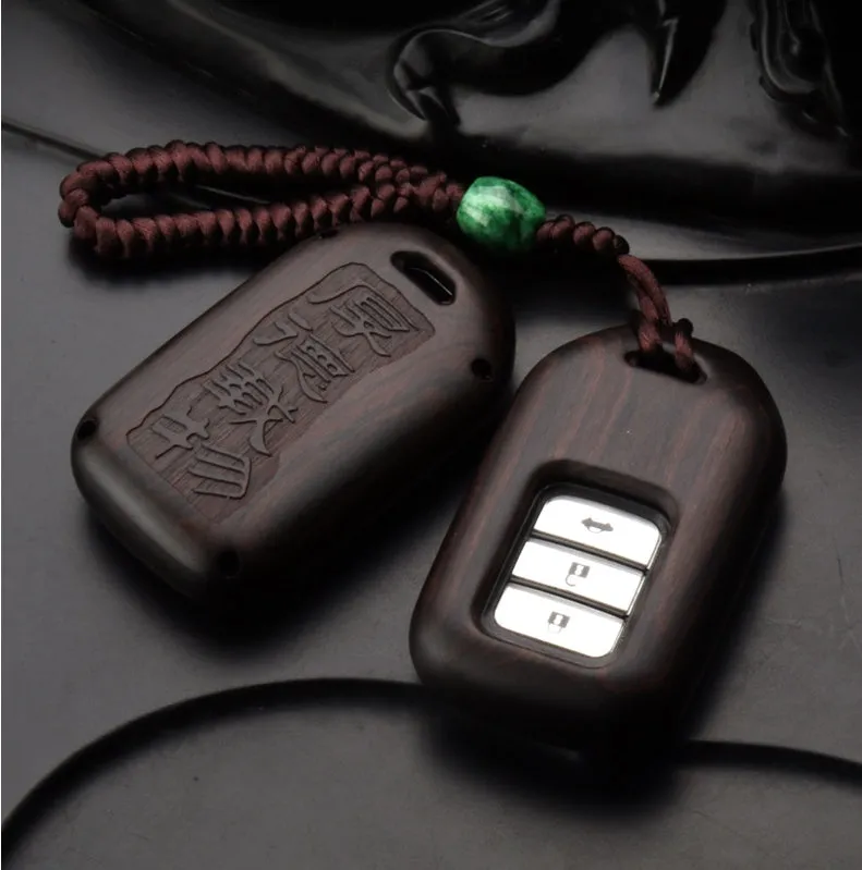 Solid ebony sandalwood key case with key rings, showing carved wood grain on a plain background