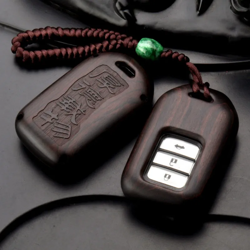 Solid ebony sandalwood key case with key rings, showing carved wood grain on a plain background