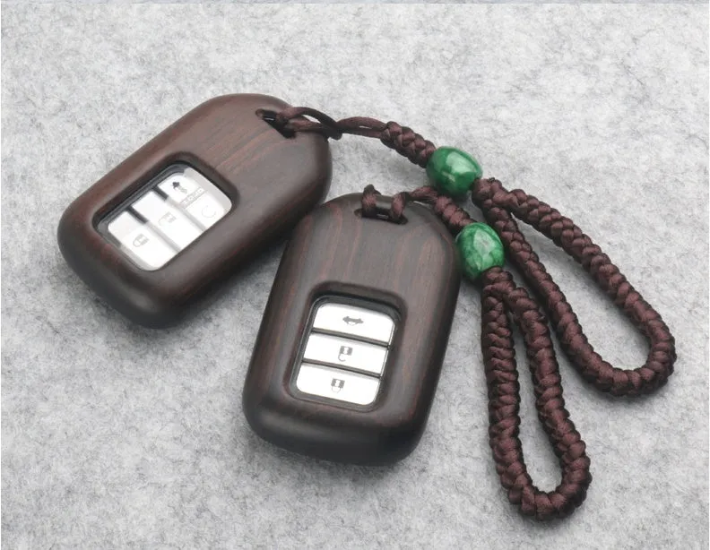 Solid ebony sandalwood key case with key rings, showing carved wood grain on a plain background