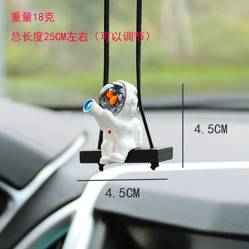 Resin astronaut car pendant showing cartoon astronaut designs including telescope, red flag, and radish variations