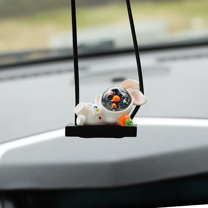 Resin astronaut car pendant showing cartoon astronaut designs including telescope, red flag, and radish variations