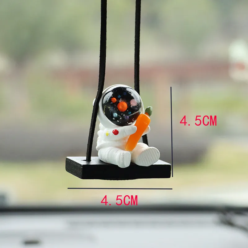 Resin astronaut car pendant showing cartoon astronaut designs including telescope, red flag, and radish variations